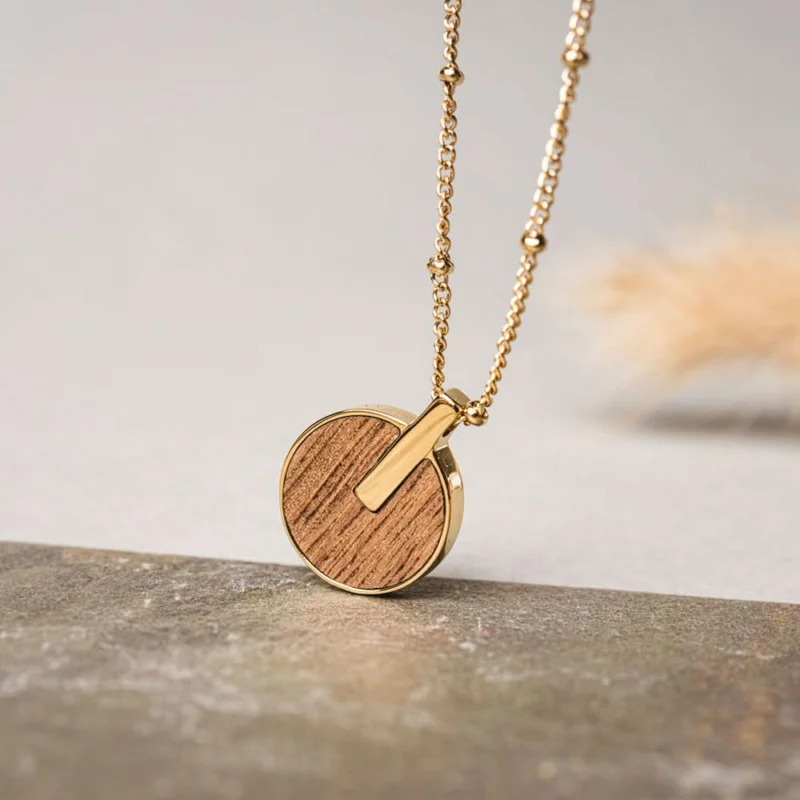 Halskette mit goldfarbener Kette und rundem Holzanhänger, mit kleinem Ausschnitt