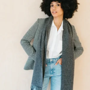 TBCo Lambswool Scarf in Charcoal Melange styled with plaid blazer and light denim jeans against neutral backdrop
