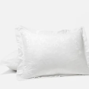 Coyuchi Heritage Percale Jacquard pillow sham in white with floral pattern.
