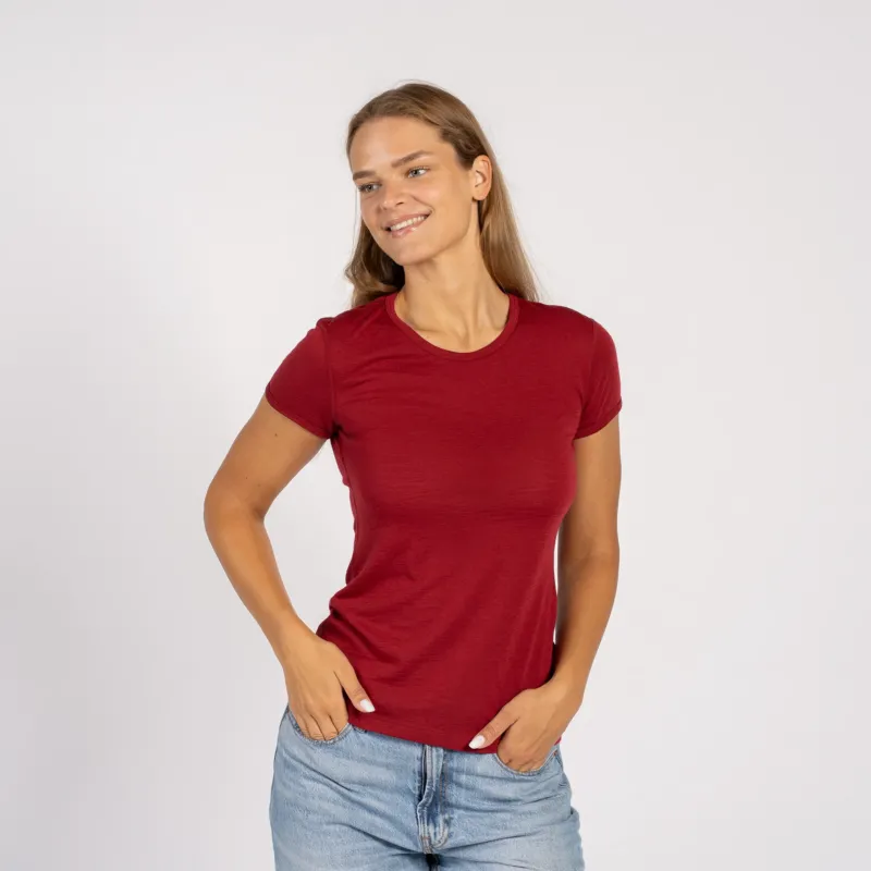 Woman wearing a merino wool menique royal cherry t-shirt and denim jeans standing in white background.