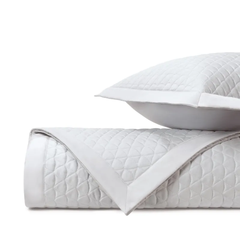 Home Treasures Anastasia white quilted coverlet rolled with matching euro sham.