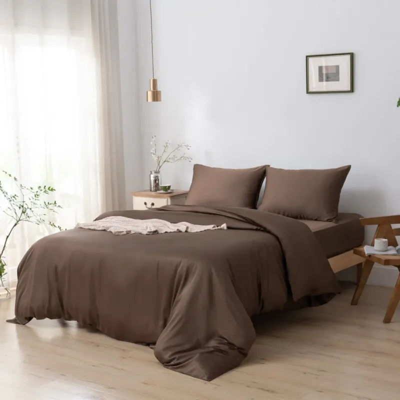 Bamboo duvet cover in Coffee Brown styled on a bed with a hanging pendant light and framed art