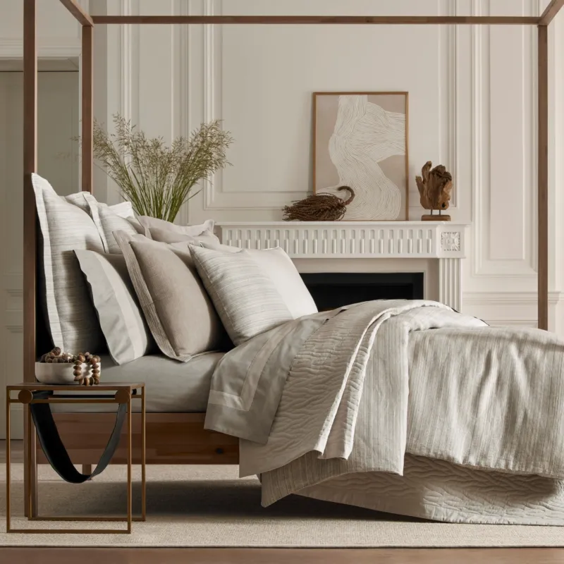 Home Treasures Boheme quilted coverlet and euro sham set in ivory on a canopy bed.