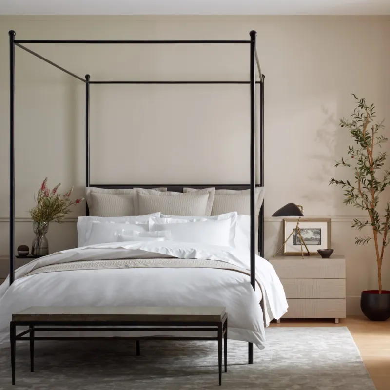 Home Treasures Darcy quilted coverlet in ivory on a black four-poster canopy bed.