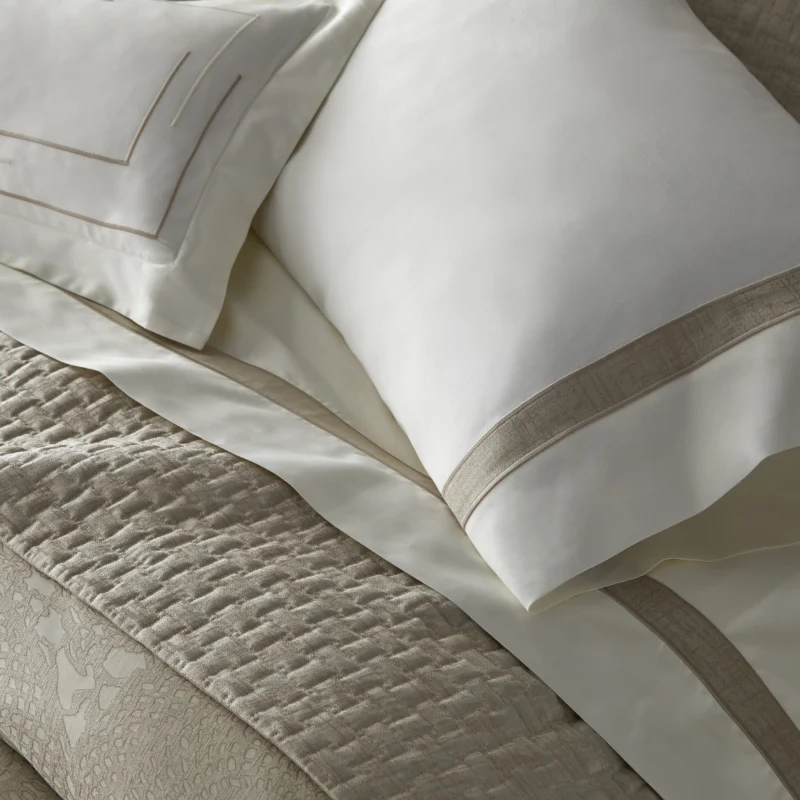 Home Treasures Fiona ivory and champagne quilted coverlet with matching euro shams on bed.