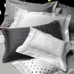 Dea Minerva Embroidery white pillowcases with charcoal geometric accent pillow.